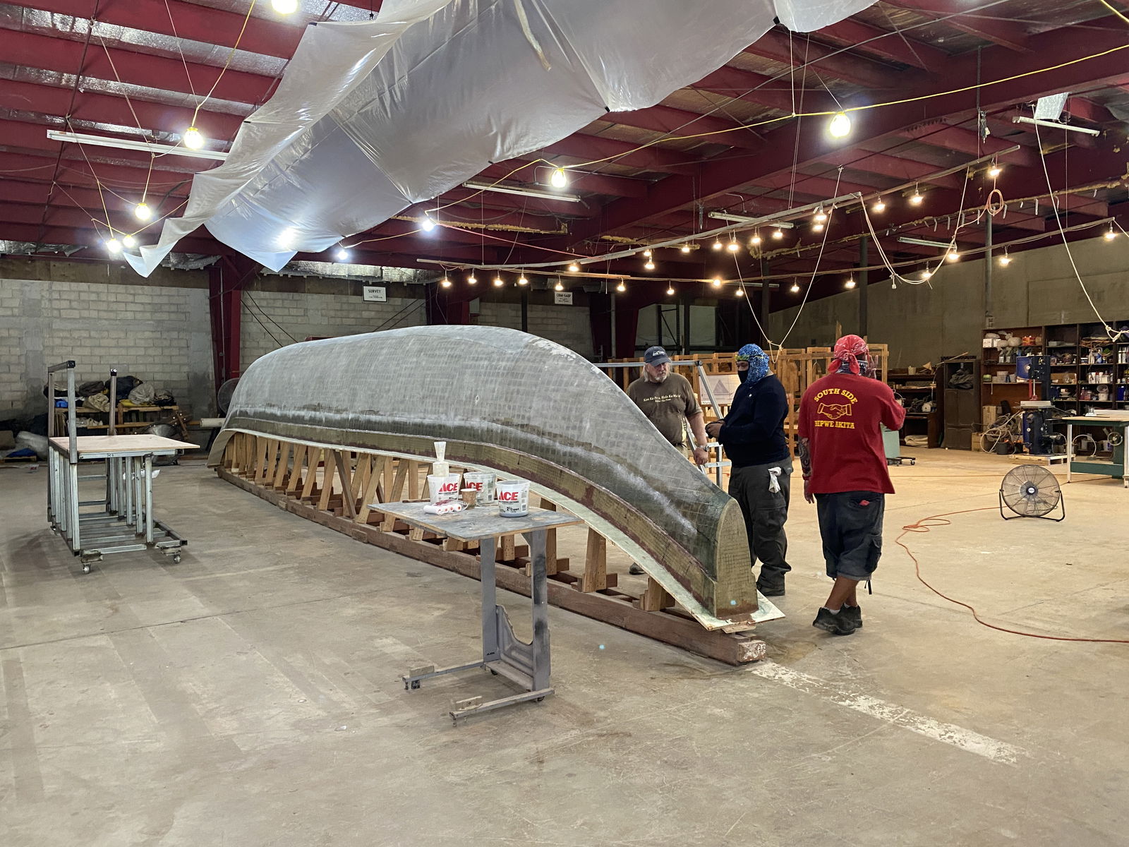 Bob Perkins, left, is assisted by local boat builders at the 500 Sails Boatyard in Lower Base on Tuesday, July 29, 2025.