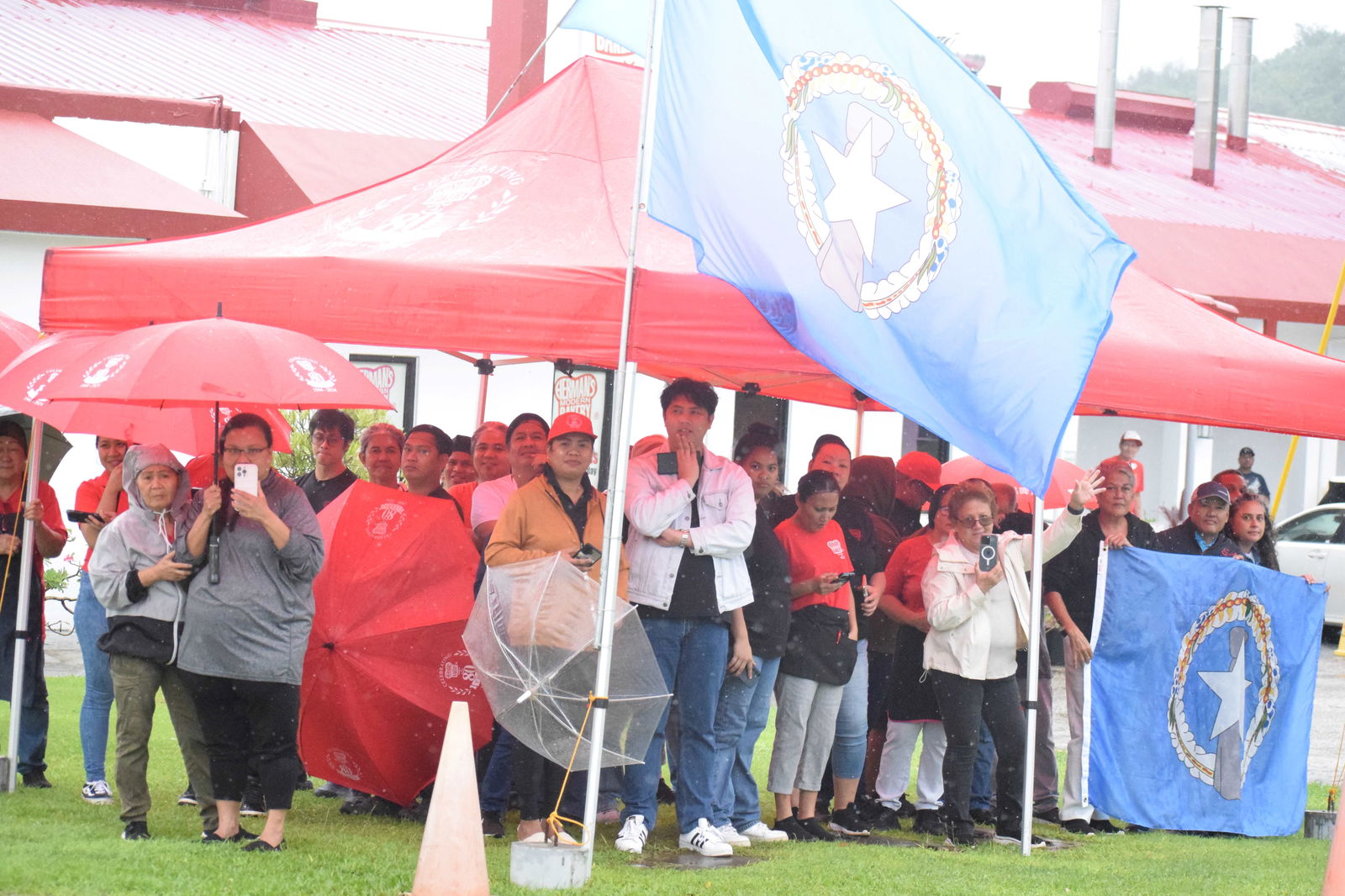 Members of the Herman R. “Pan” Guerrero family and some of their employees gather outside Herman's Bakery and Café to pay tribute to the late governor on Airport Road.