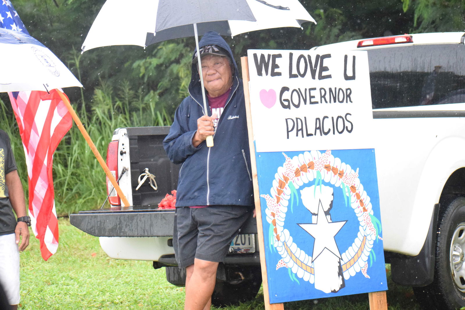 Along Airport Road, a resident holds a sign that reads, “We Love You, Governor.”