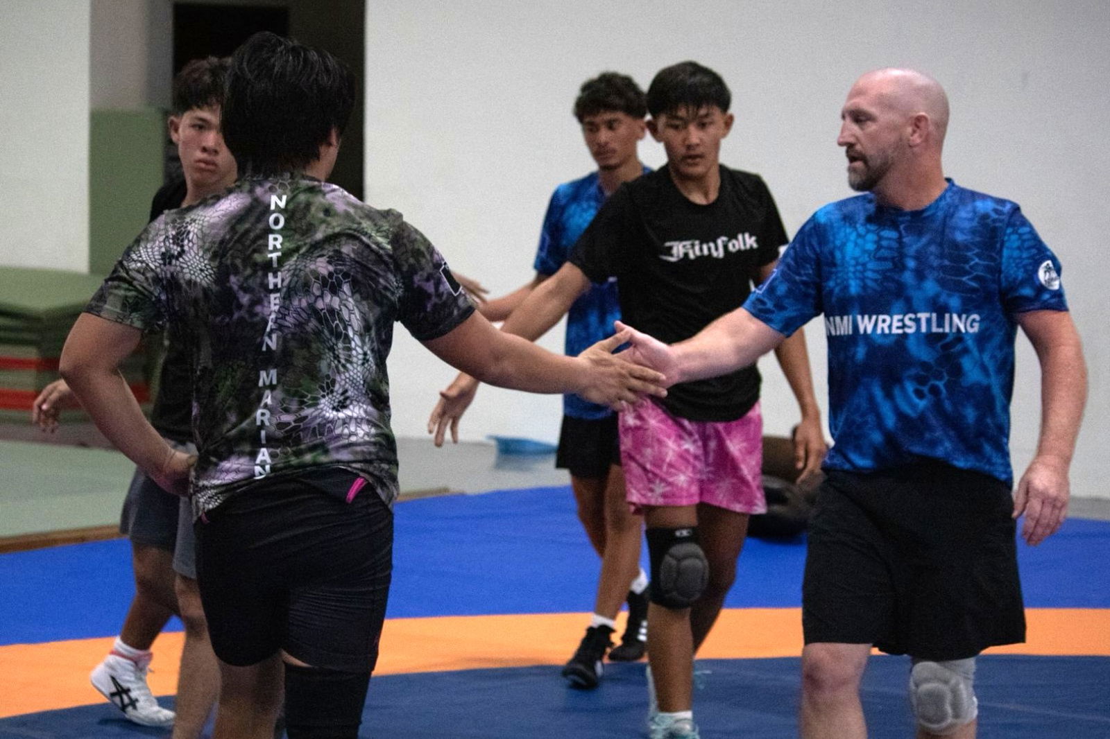 Vincent Palacios, second right, joins his teammates and coach Rick Bauer, right, in the training session in Palau. Palacios won the first medal for Team Marianas after securing a silver in the 60kg freestyle wrestling.Marianas Press via NMSA