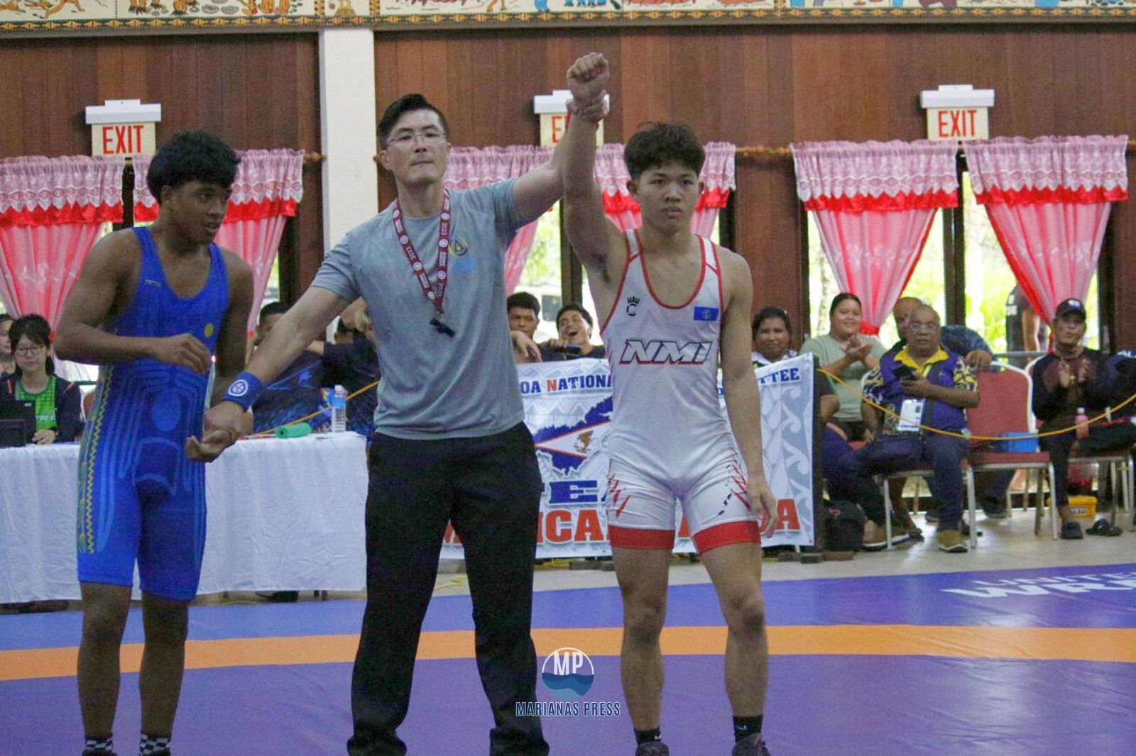 Seth Sablan, right, is declared the winner in his gold medal bout against Palau’s Kane Tarkong in the men’s 65kg class Greco wrestling competition in the 2025 Pacific Mini Games in Palau early this month.Marianas Press photo