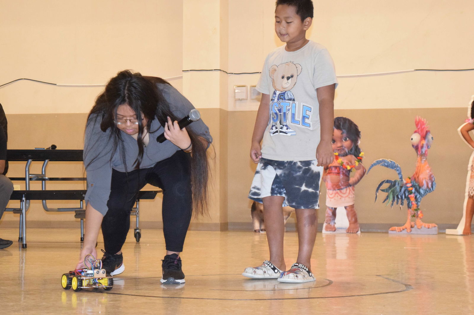 Nathalie Matsunaga shows a boy how to interact with the robot Curiosity.