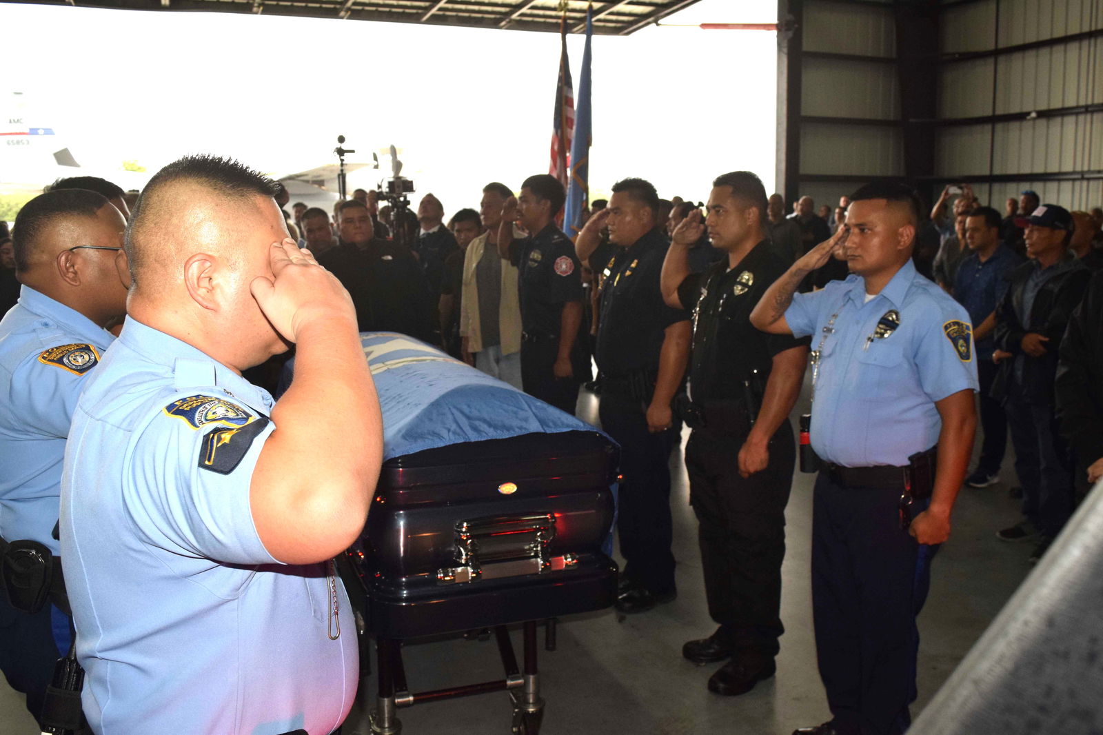 Department of Public Safety officers salute the late governor’s casket before it is carried to the hearse.