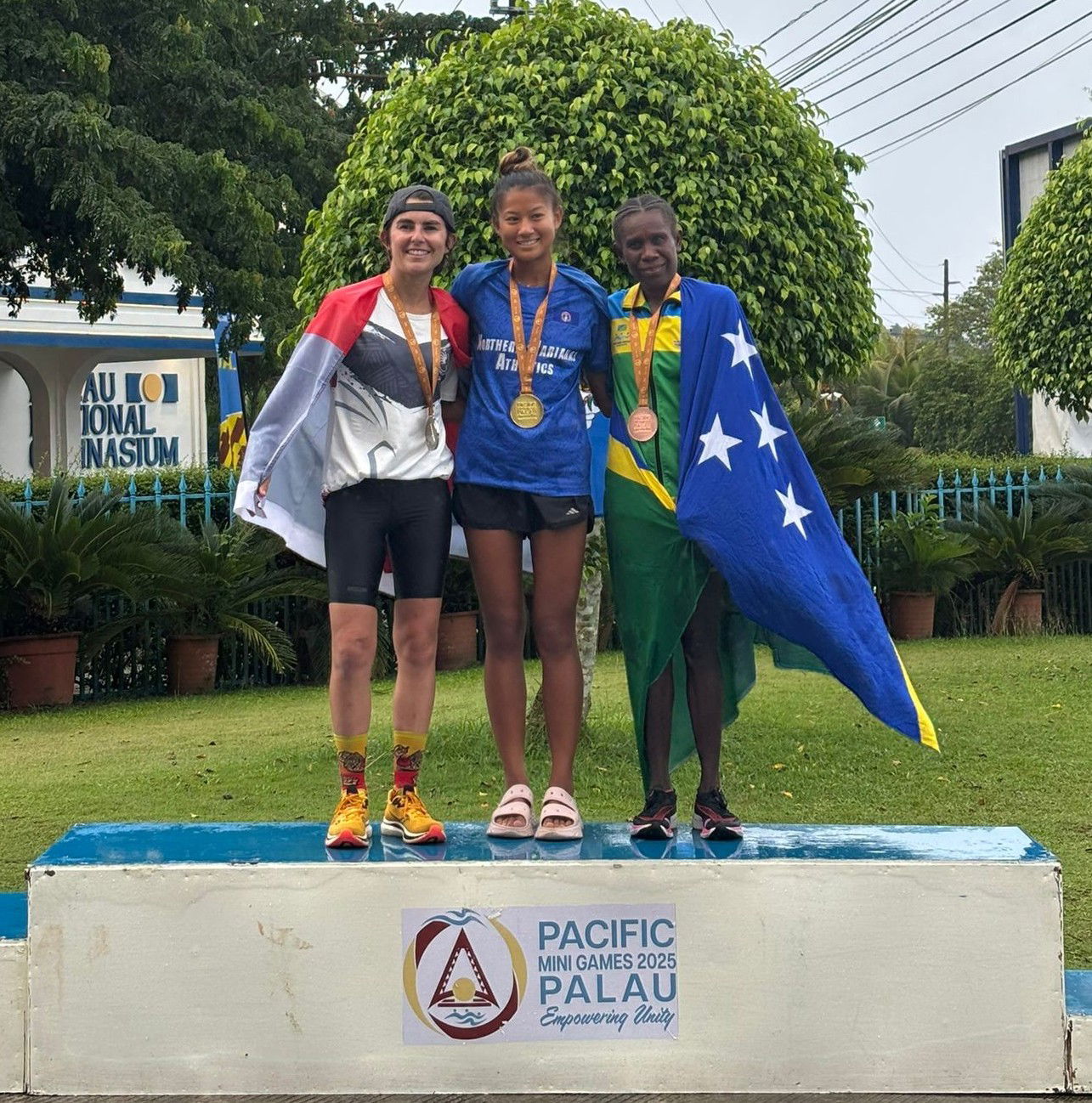 NMI’s Tania Tan, center, leads the podium finishers in the women’s half marathon event at the 2025 Pacific Mini Games in Palau on Wednesday. She is joined by silver medalist Natalia Prado Alfonso of New Caledonia and bronze medalist Dianah Matekali of Solomon Islands.Marianas Press photo