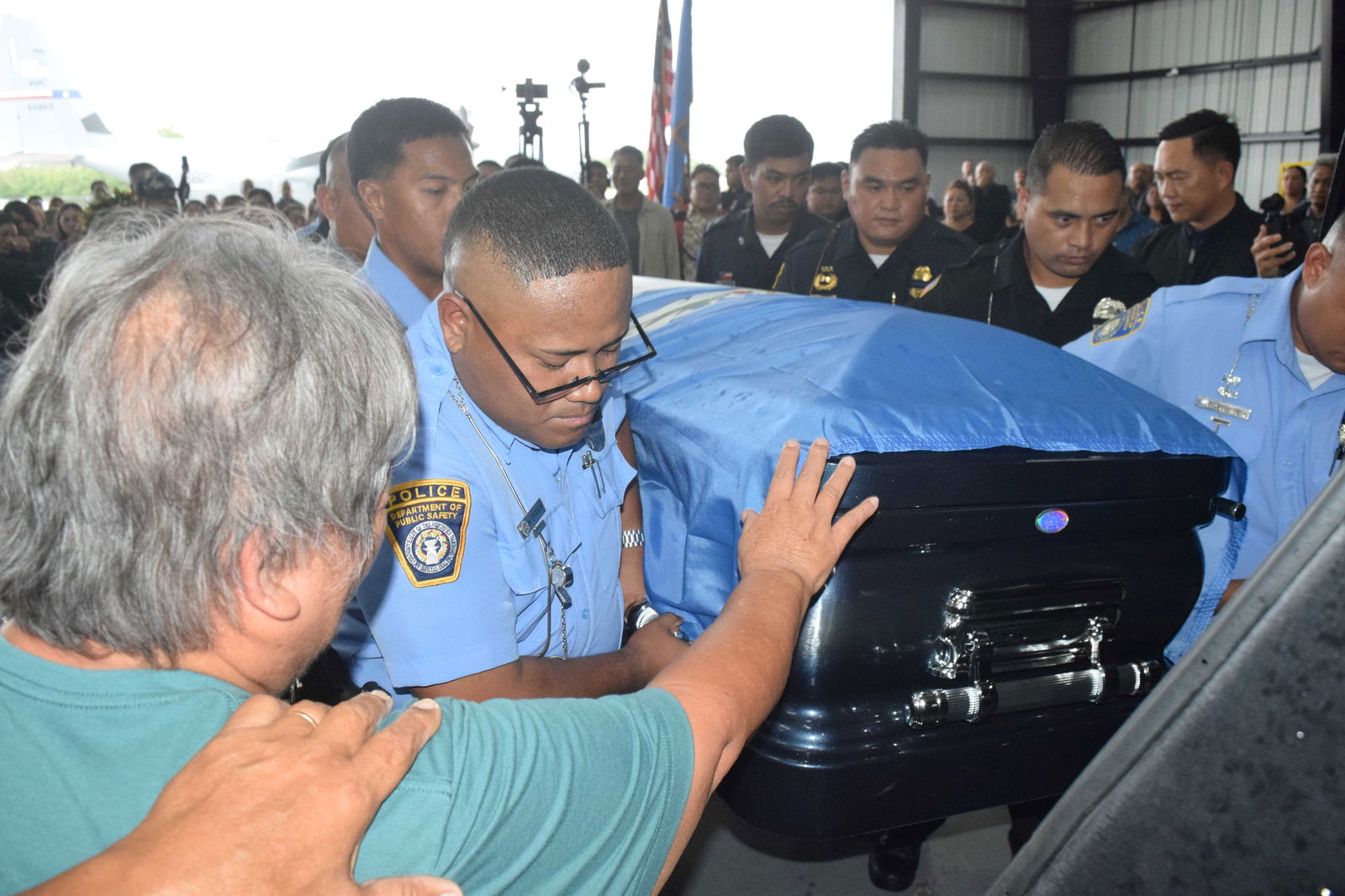 An emotional Nicolasa Indalecio Celis extends a hand toward the casket of her nephew, the late governor.