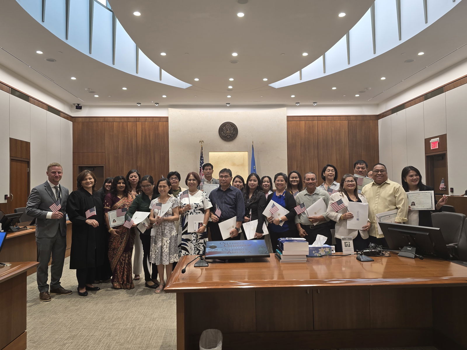 The new U.S. citizens sworn in on July 7, 2025 pose for a photo with Chief Judge Ramona V. Manglona of the District Court for the NMI and U.S. Citizenship and Immigration Services Officer Riley Huskey.District Court for the NMI photo