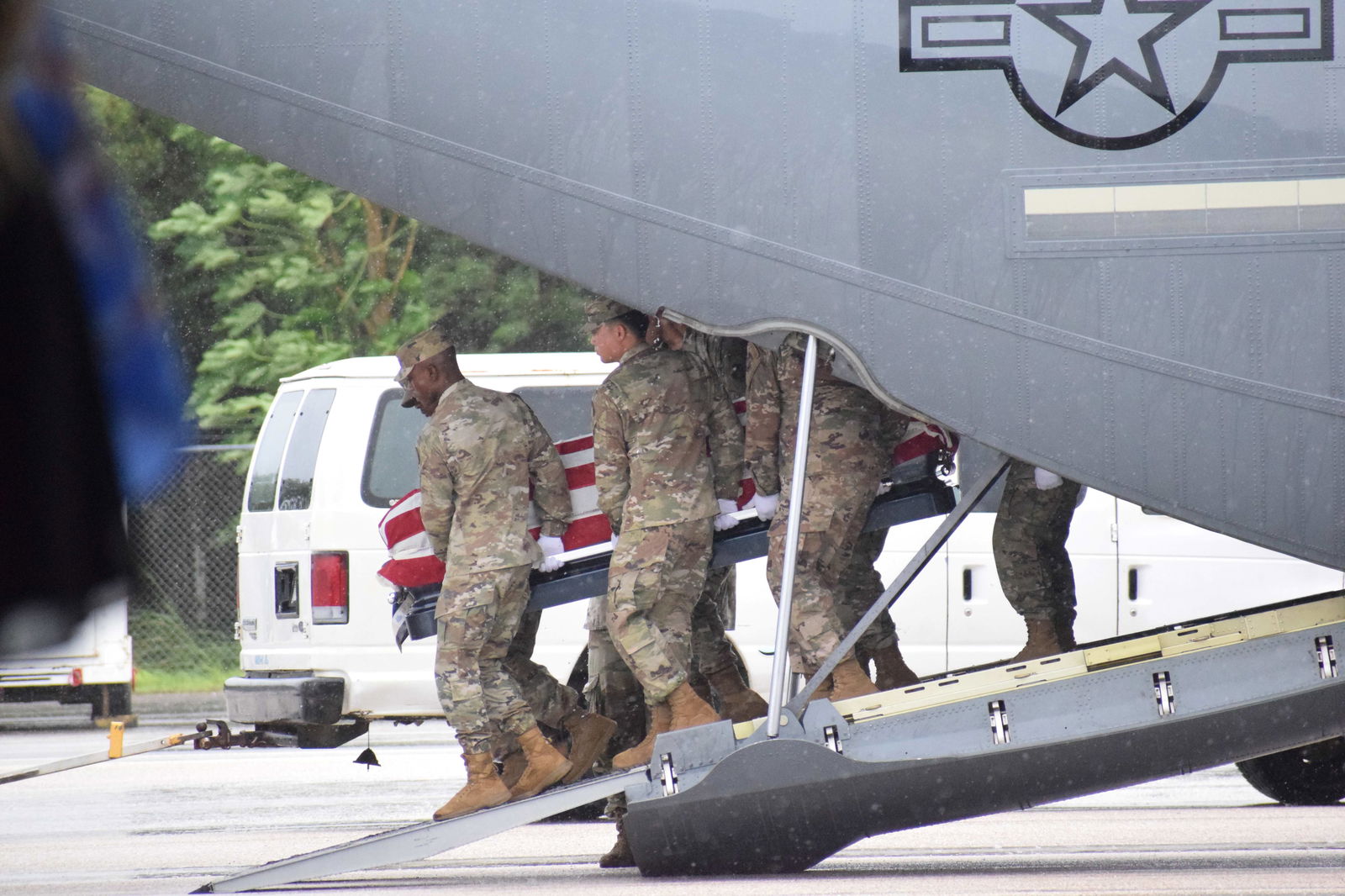 U.S. service members carry the casket bearing the remains of the late governor.
