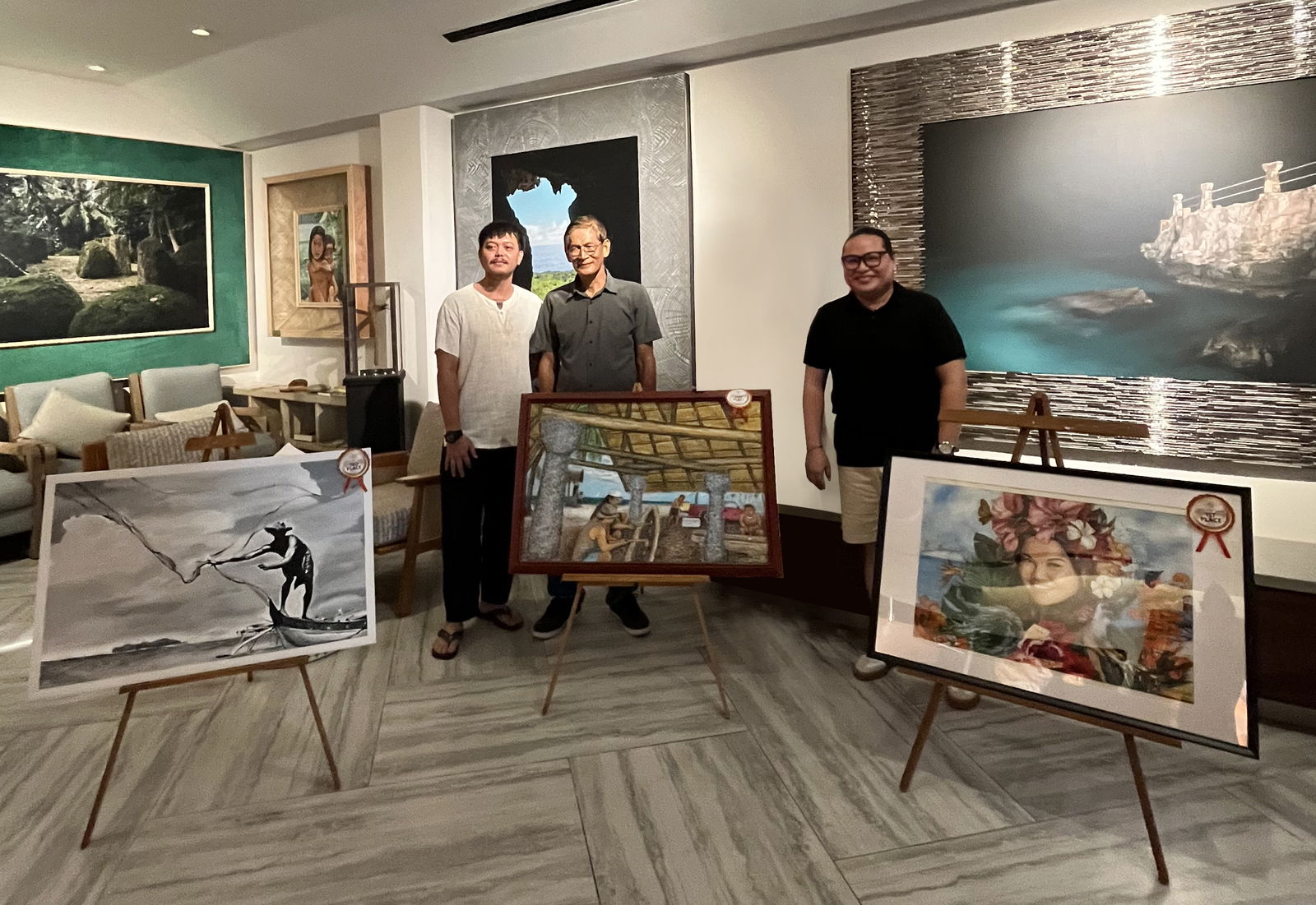 From left, Robert Neil Alvarez, Greg Bacnis, and Christian Apolonio pose for a photo with their winning artworks at The Cultural Lounge of Crowne Plaza Resort Saipan, during the awarding ceremony on July 17. The three artists earned 3rd, 2nd, and 1st place, respectively, in the inaugural CPRS Artist of the Summer Art Contest.Contributed photo