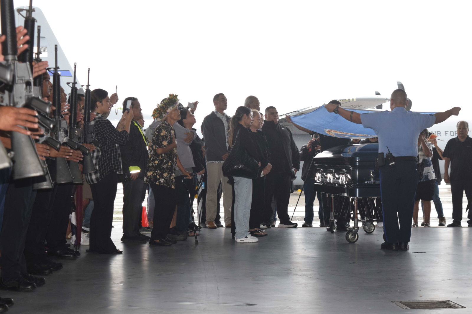 Department of Public Safety officers drape the CNMI flag over the late governor’s casket while fellow officers stand at attention.