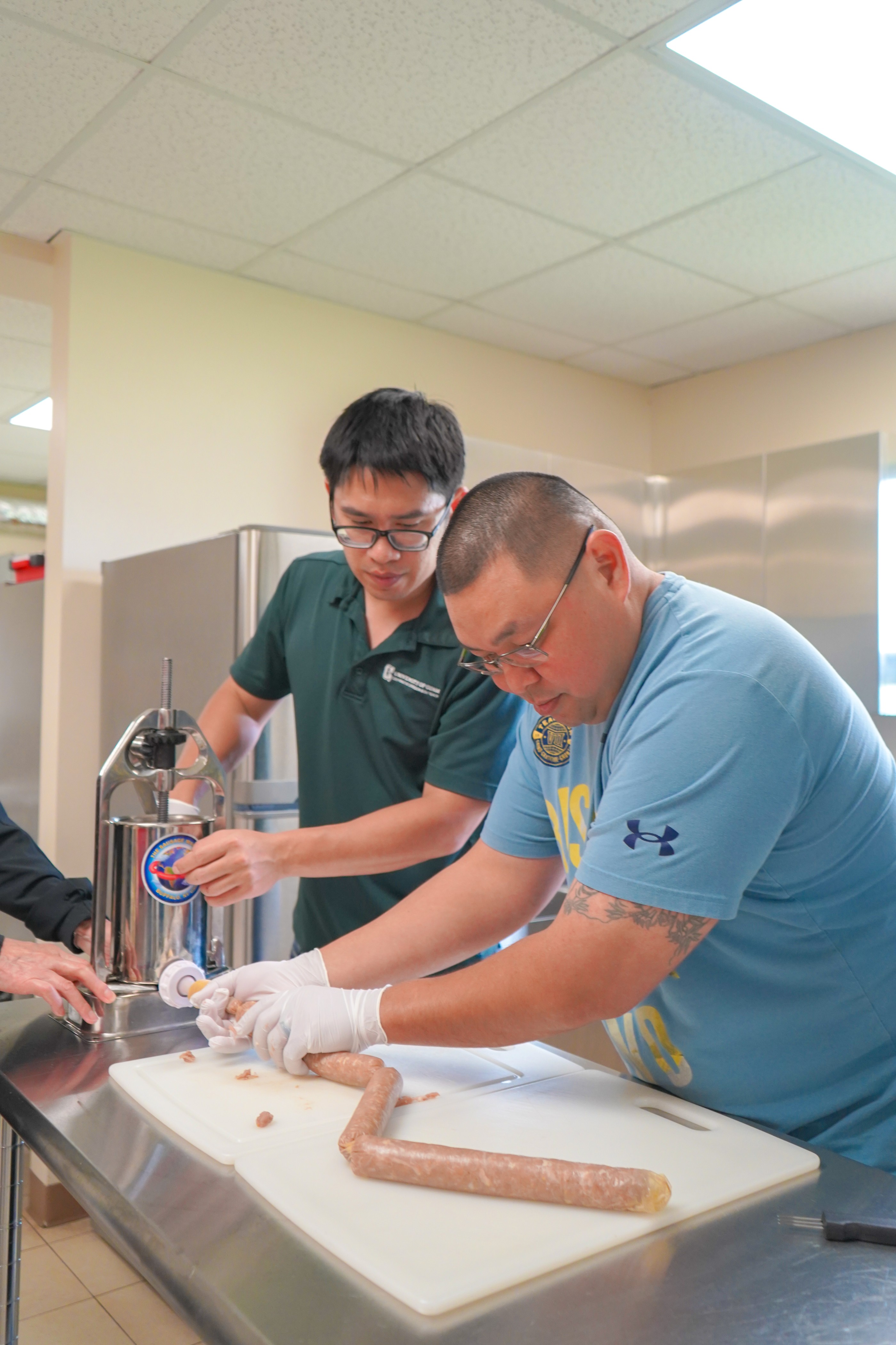 Marvin Crisostomo and Dr. Jeng-Hung Liu, meat scientist with the University of Guam Land Grant Extension Service, feed pork into sausage casings during a meat processing workshop held in August 2023 at UOG.Photo courtesy of University of Guam