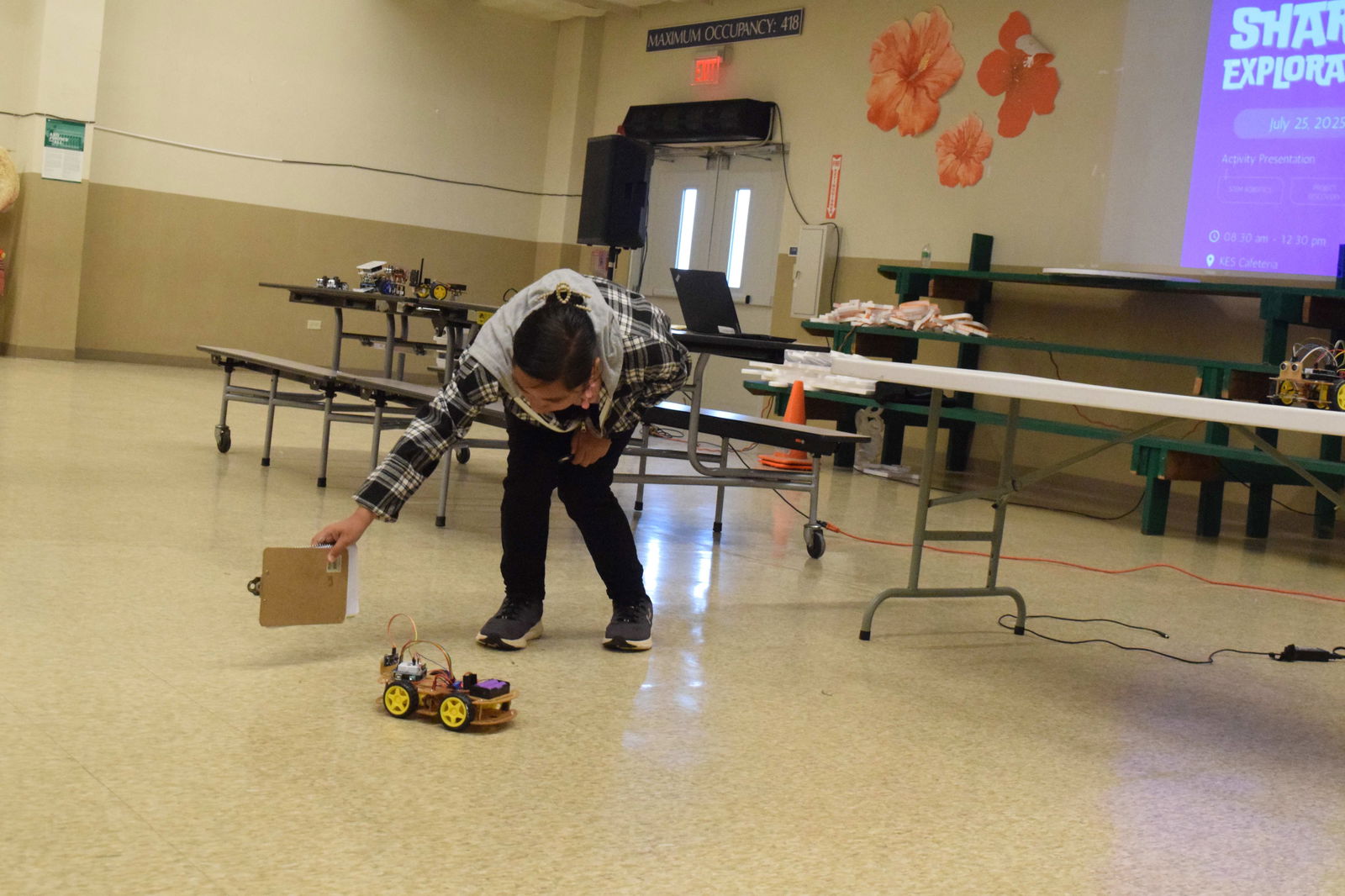 Da’ok student Britney Lizama demonstrates how her team’s robot, Willy, works during the Summer 2025 Sharks Exploration STEM Robotics exhibit at Koblerville Elementary School cafeteria on Friday.
