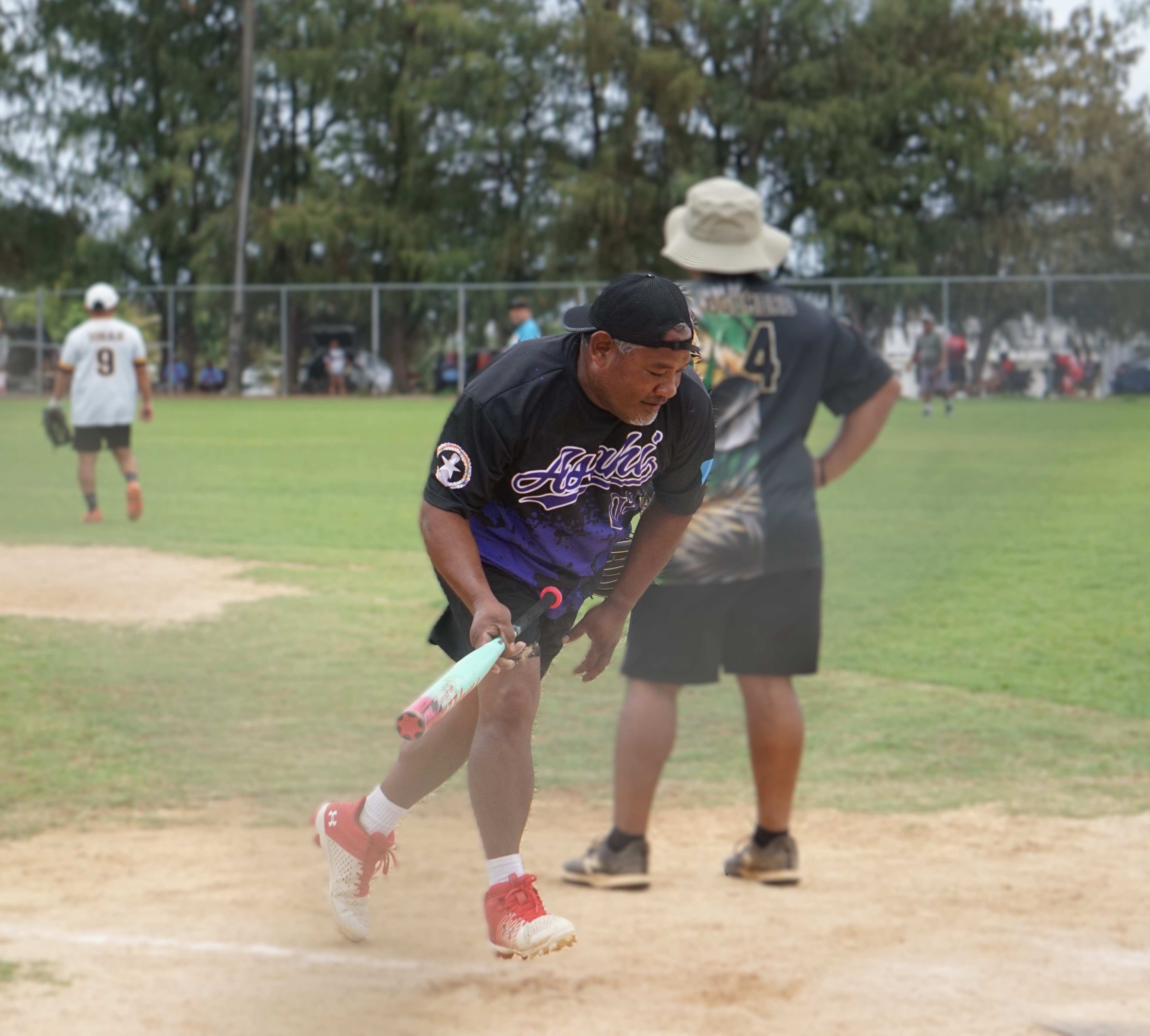 Taylor Germance collects his bat after hitting a homerun in a masters division game of the 2025 Budweiser Belau Amateur Softball Association League at the Dandan ball field.Photo by James F. Sablan Jr.