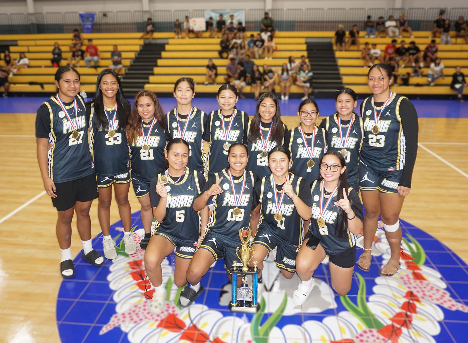 Prime players pose with the women's division championship trophy of the  2025 Allied Pacific Environmental Consulting Basketball League during the awards ceremony at the Ada gym on Thursday night.Photo by James F. Sablan Jr.