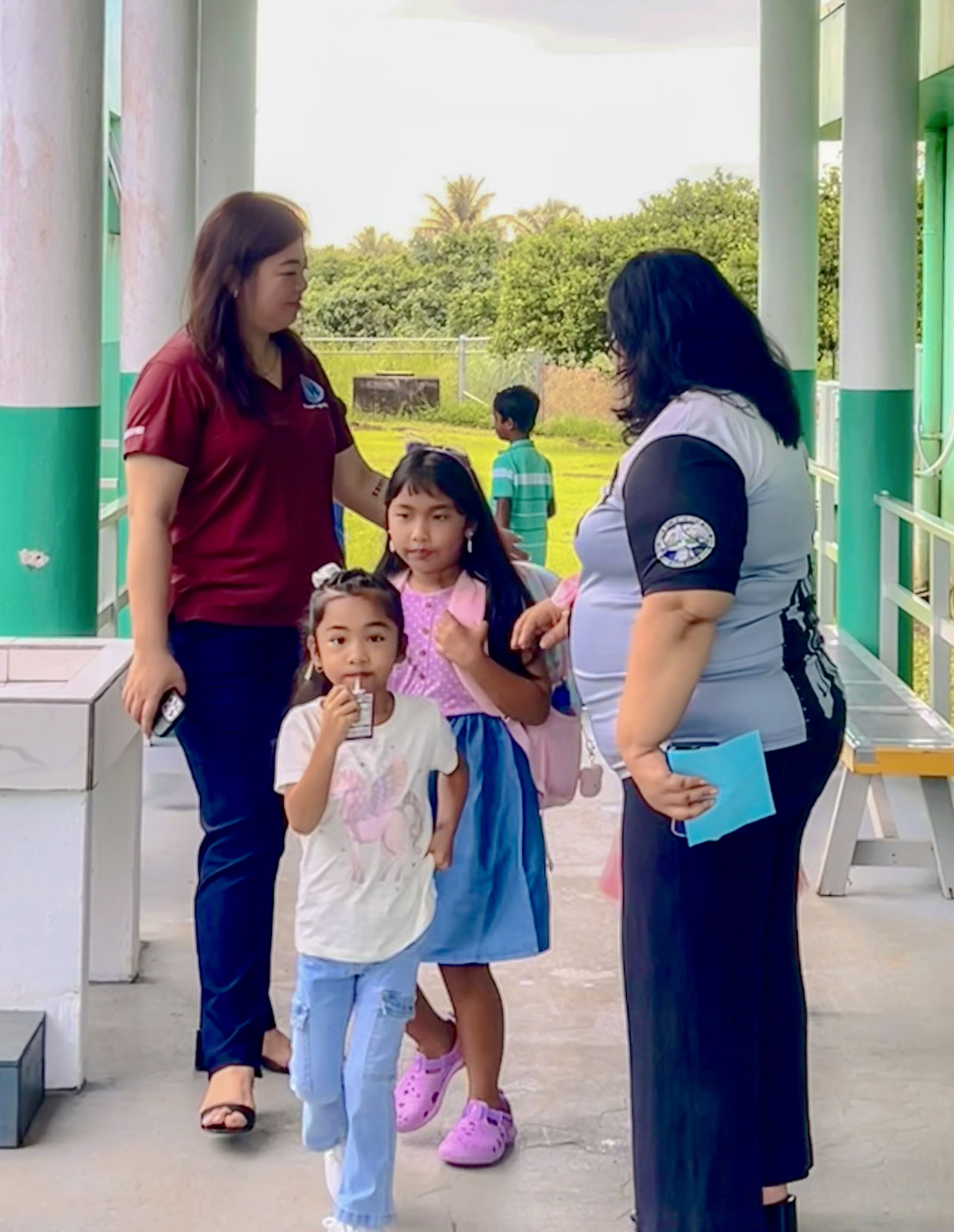 PSS Federal Programs Officer Jacqueline Che and Sinapalo Elementary School Principal Daisy Quitugua greet students as they arrive on campus.