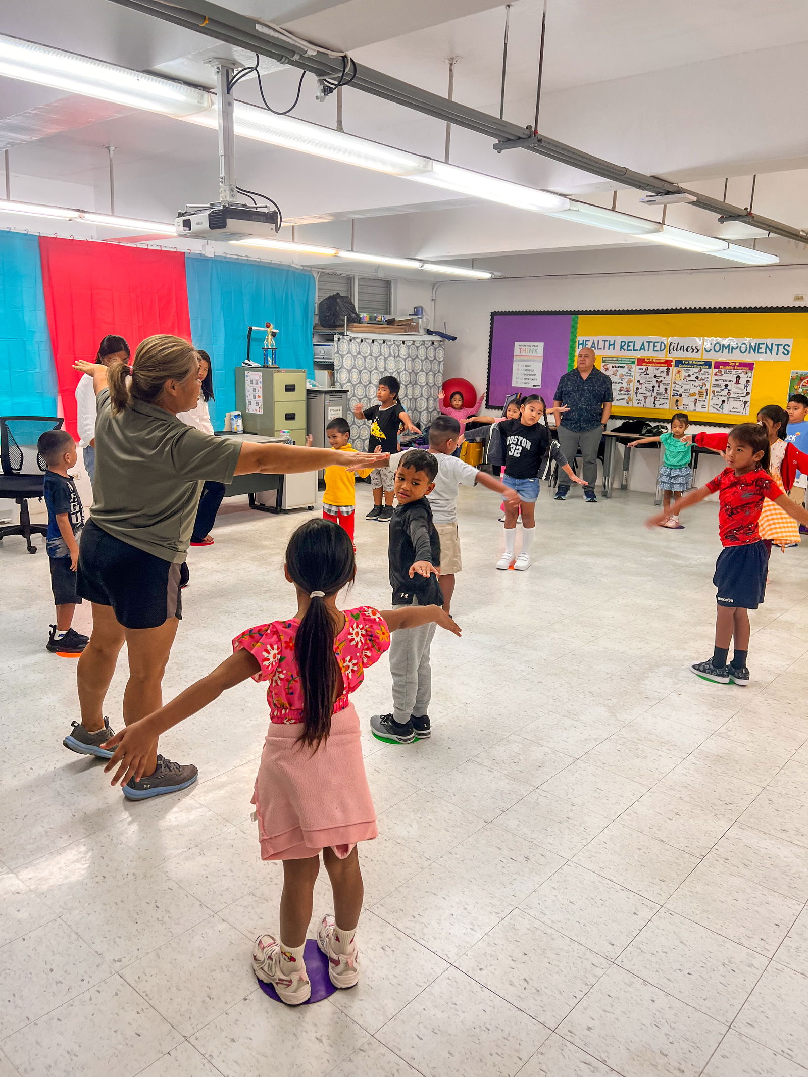 First graders at Tinian Elementary School practice movements such as jumping, galloping, leaping, and sliding during physical education class.