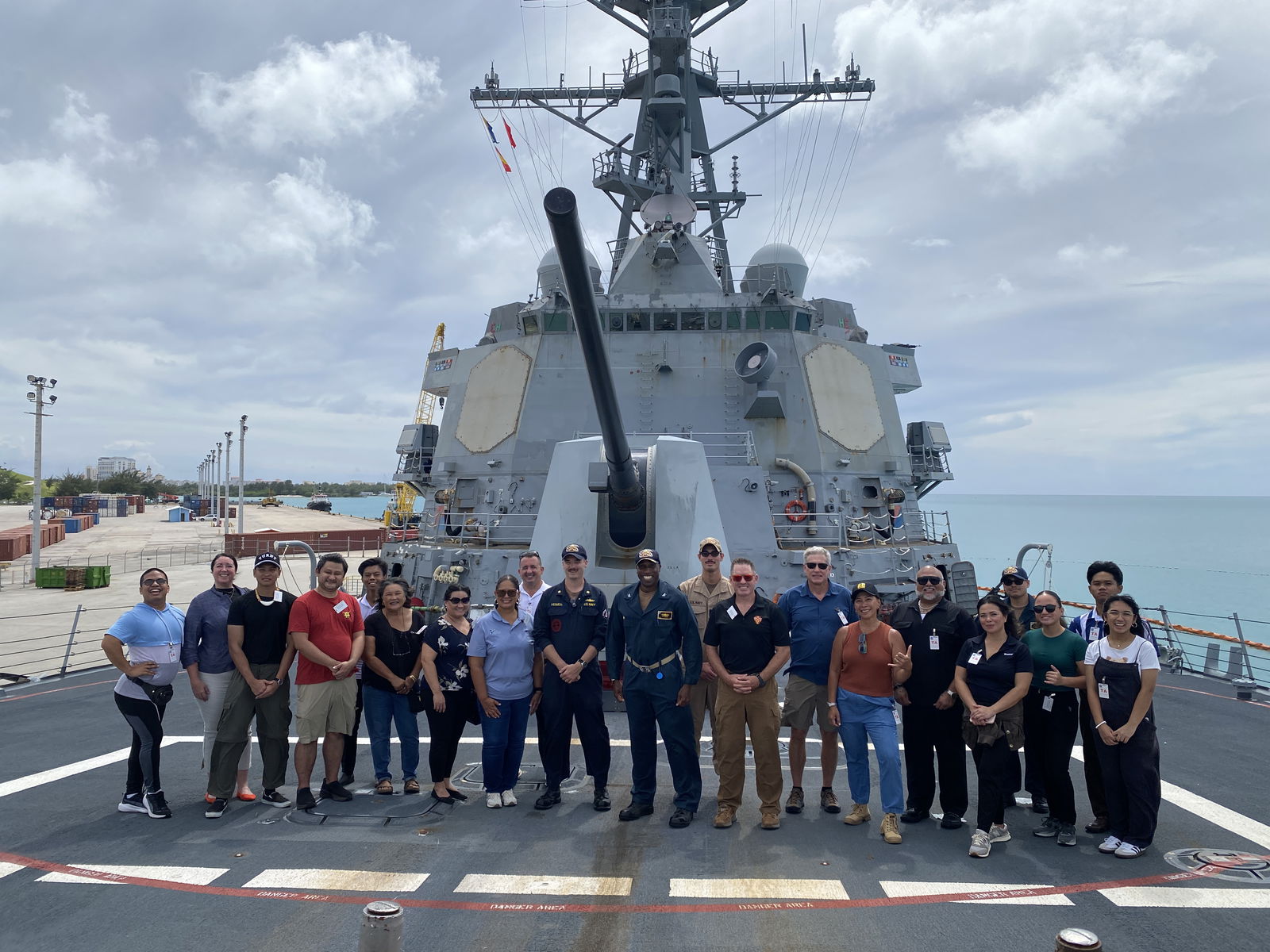 Island residents and crewmembers of the USS Shoup pose aboard the ship.