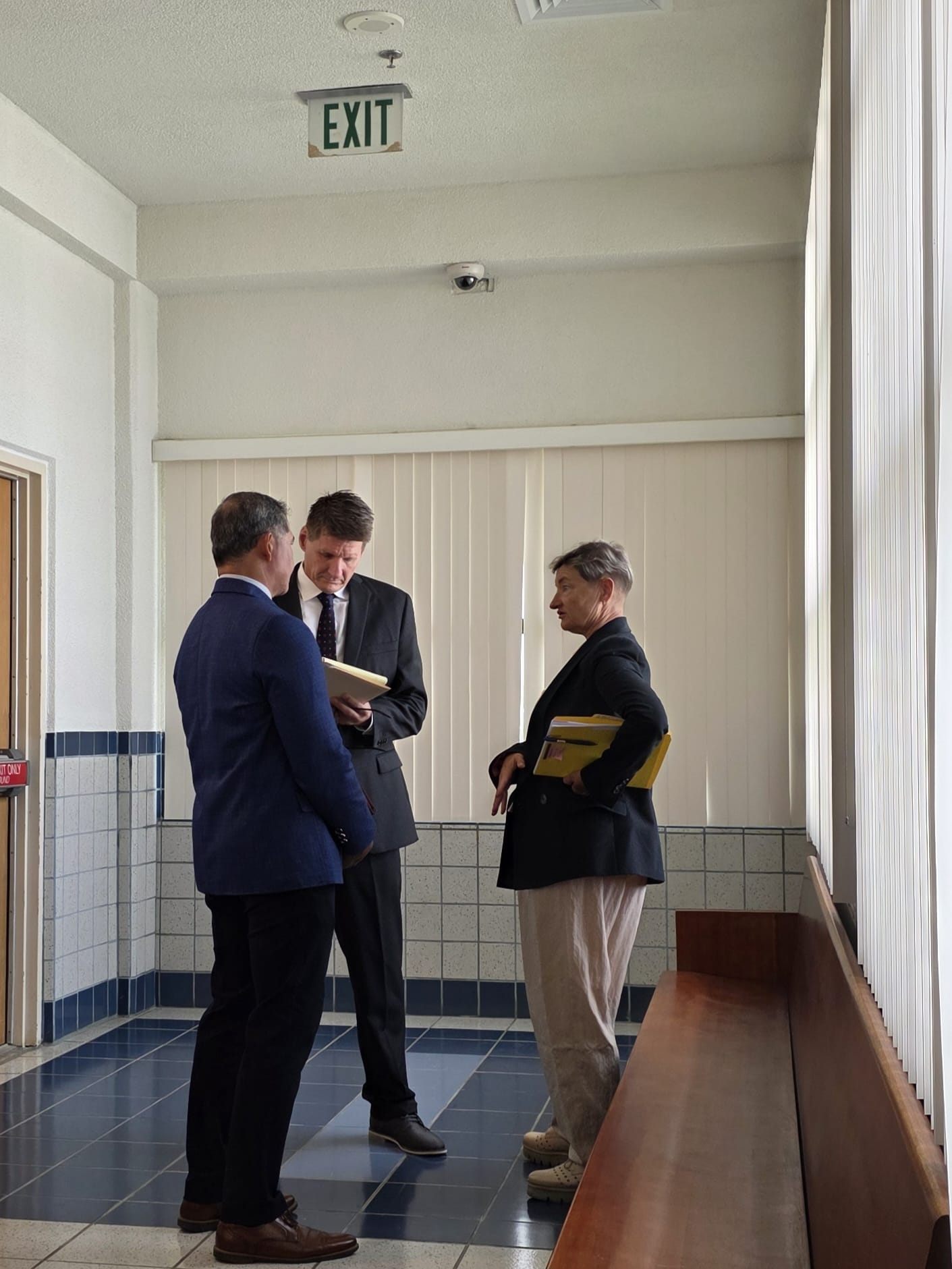 The Office of the Attorney General’s prosecutor Olga Kelley, right, confers with defense attorneys Bruce Berline and Robert Torres outside the courtroom before Monday’s arraignment.