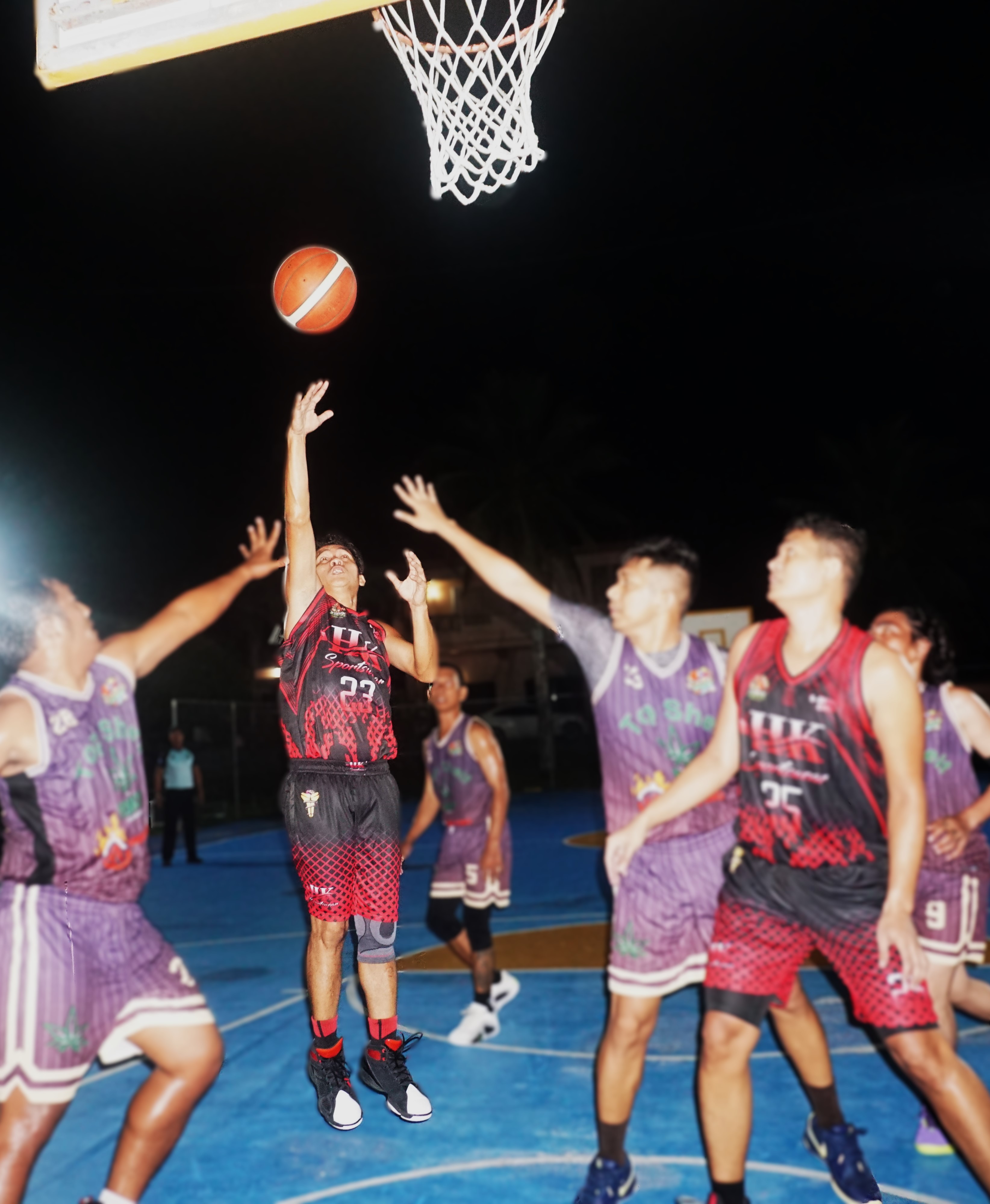 Yabangis/HK's Jun Estolas attempts a floater between defenders during a game against Top Shelf/Connie's BBQ in bracket A of the CNMI E-Sports Invitational Basketball League 2025 at the Gualo Rai Basketball Court on Saturday night.