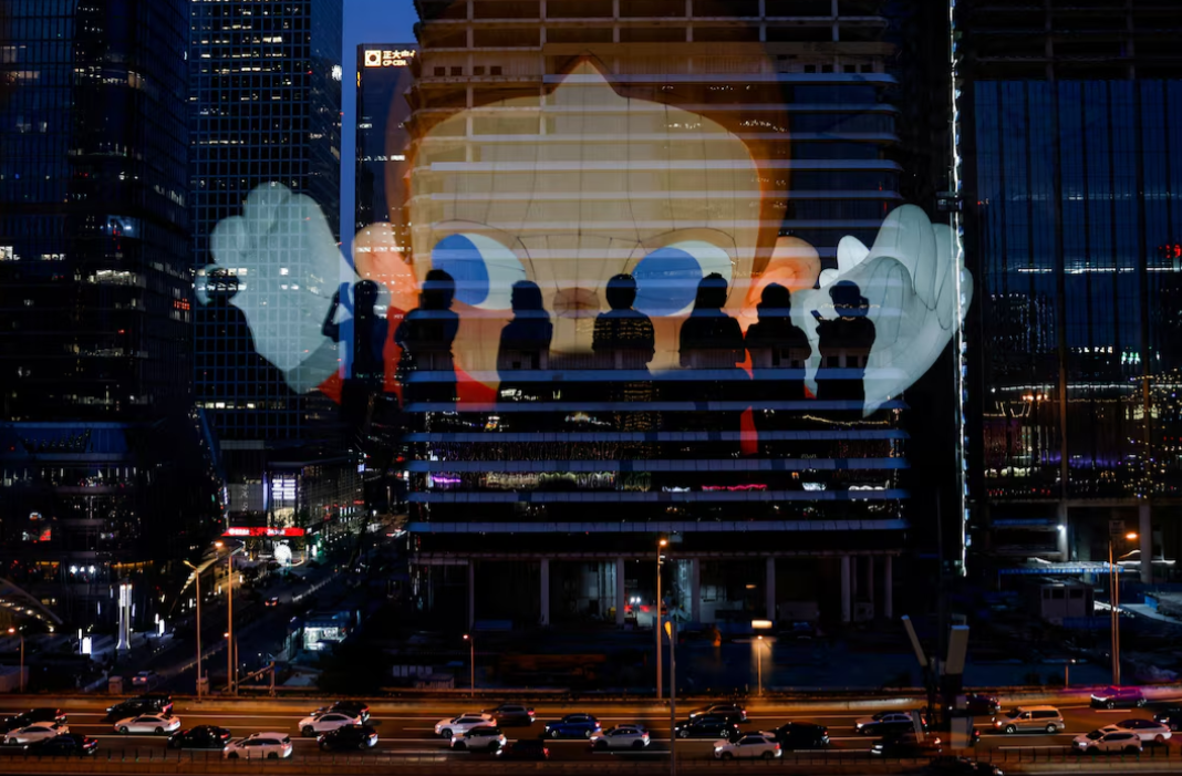 The reflection of silhouettes of people is visible on a glass on a terrace of a shopping mall overlooking Beijing's central business district in China, Aug. 11, 2025.REUTERS