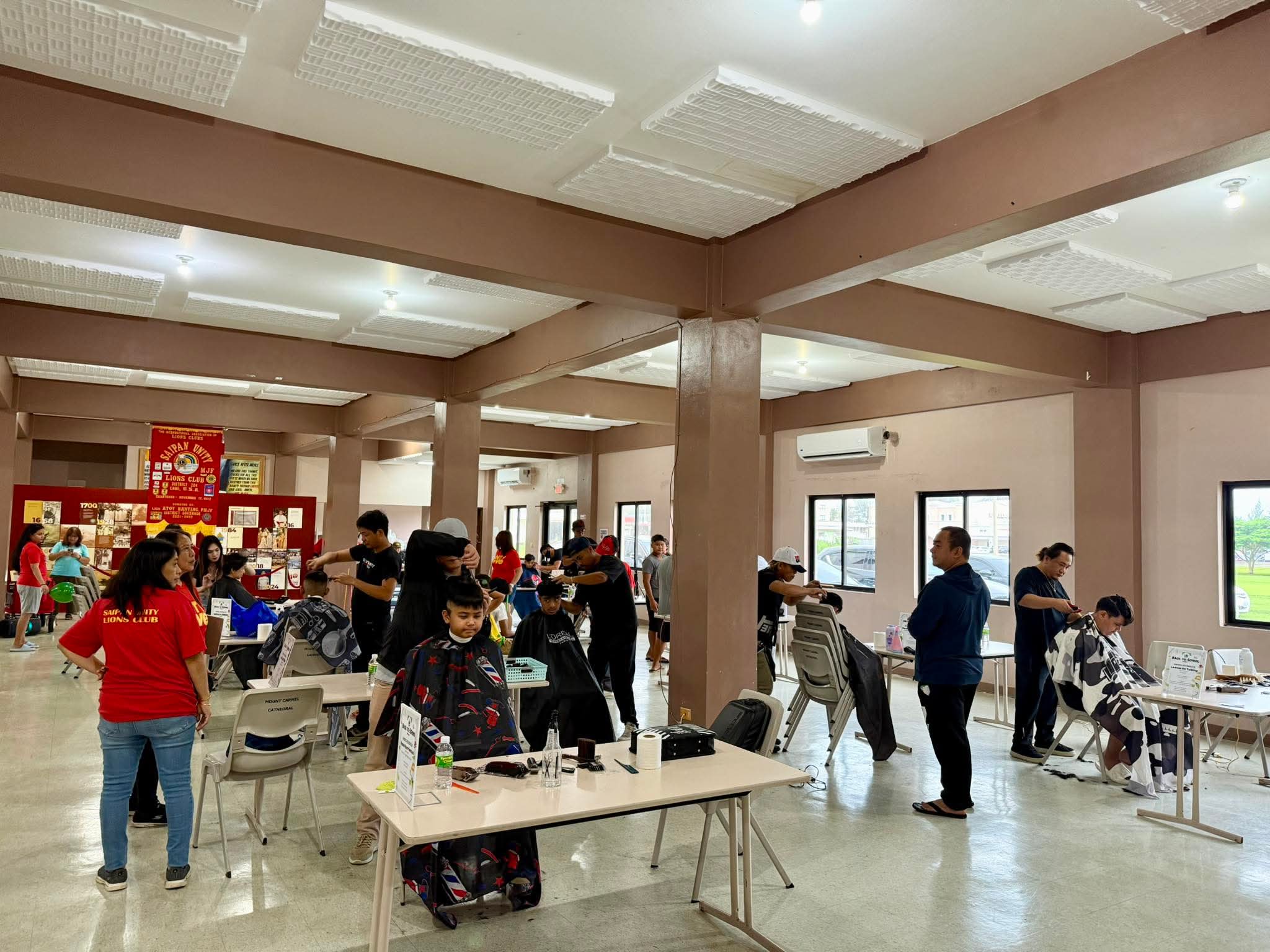Students receive free haircuts from volunteer barbers and hairdressers.