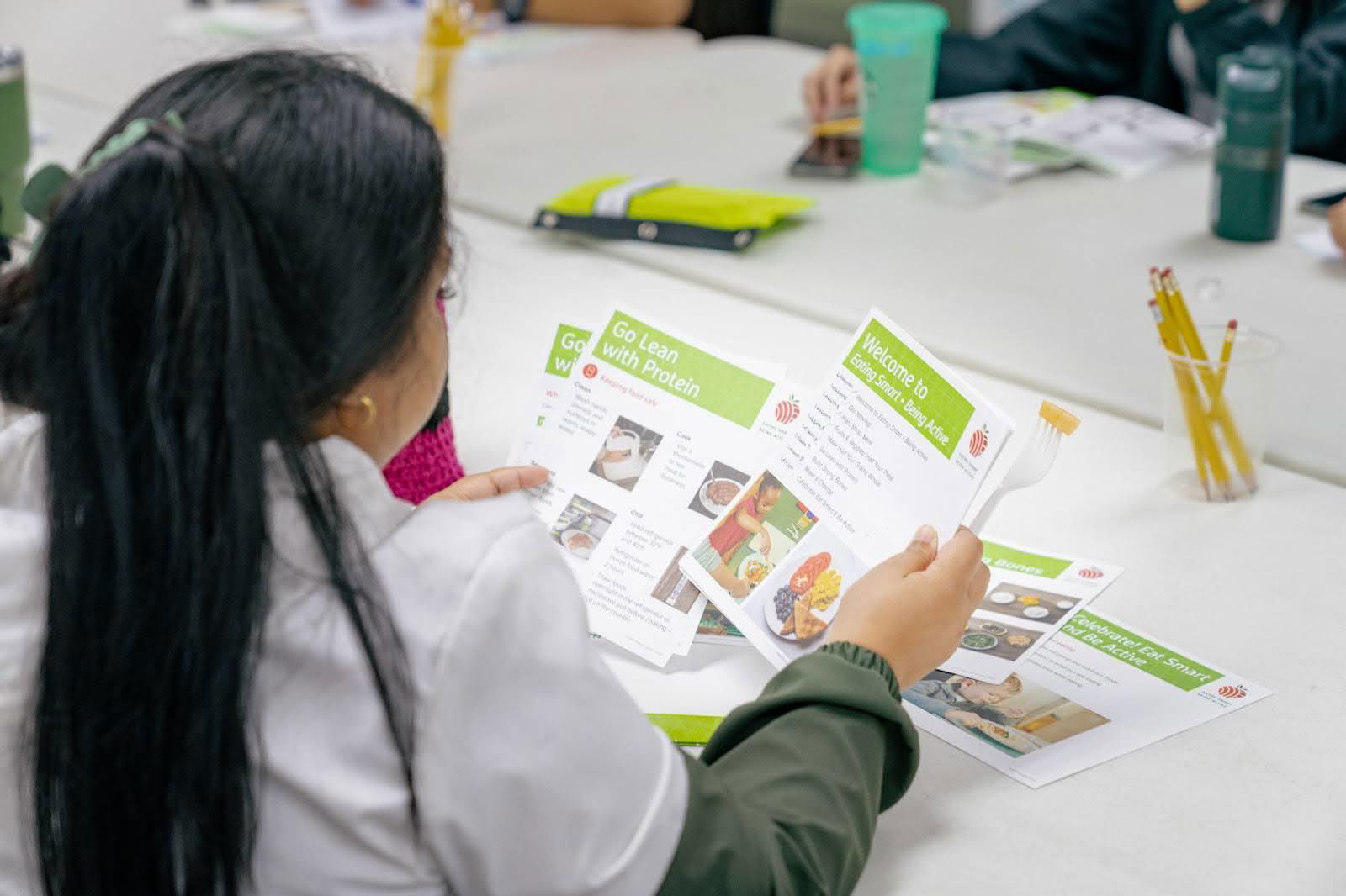 An EFNEP participant looks over the lesson handouts. Future participants can expect to see Saipan landmarks and local models.