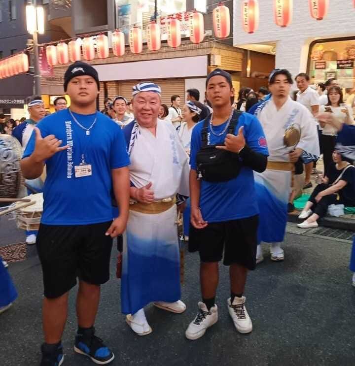 Brayden Songsong and Jonathan Agulto pose with a Japanese Awaodori musician/dancer.
