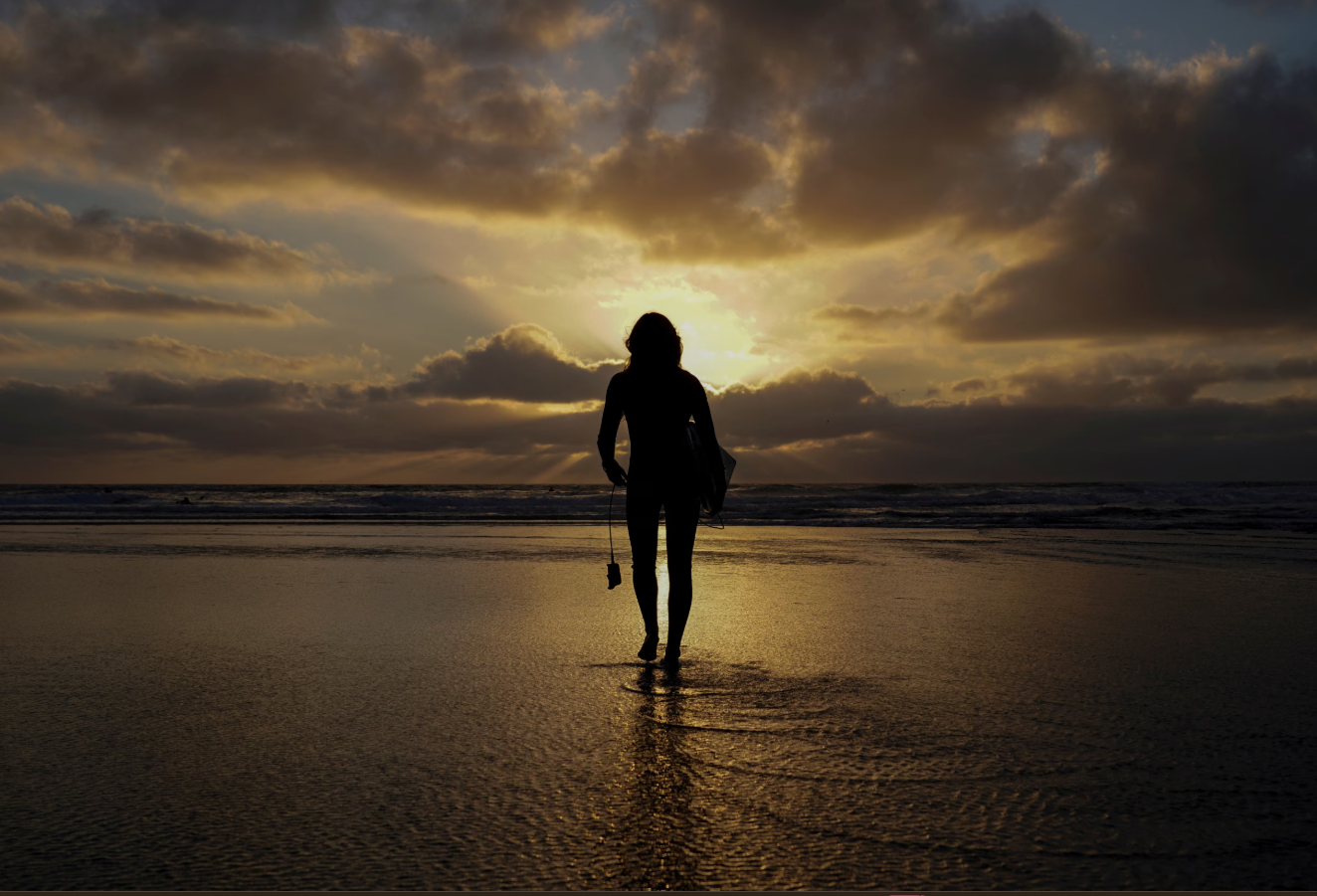 A female surfer walks out into the waves at Cardiff State Beach in Encinitas, California, Oct. 17, 2019.REUTERS