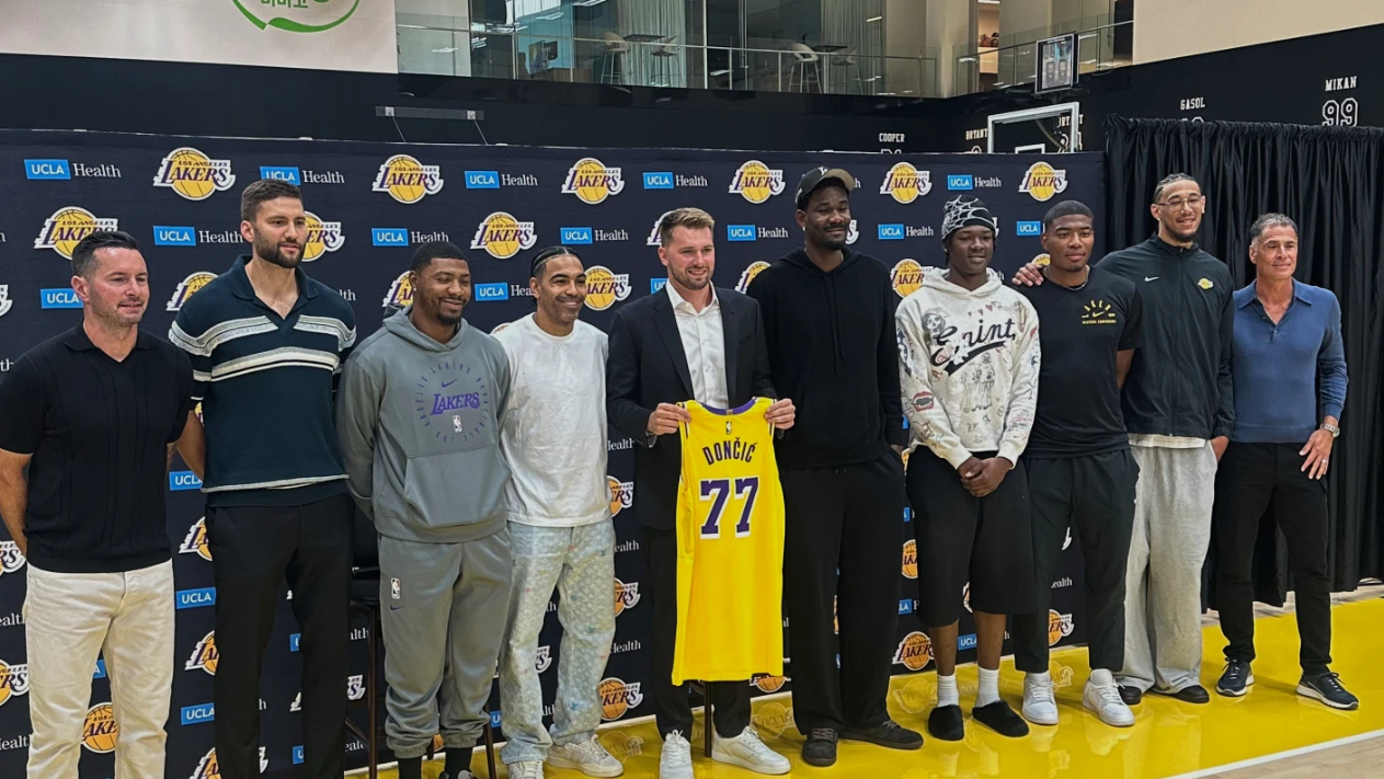 The Los Angeles Lakers, from left, Coach JJ Redick, Maxi Kleber, Marcus Smart, Gabe Vincent, Luka Doncic, Deandre Ayton, Adou Thiero, Rui Hachimura, Jaxson Hayes and general manager Rob Pelinka congratulate Doncic on his three-year, $165 million contract extension at the Lakers’ training complex in El Segundo, Calif. on Saturday, Aug. 2, 2025.AP