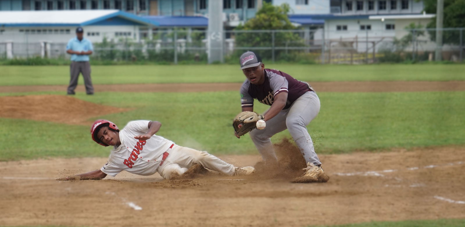 The Braves’ Justin Garde slides home in time to beat the pickoff attempt against the Comets during the Saipan Little League Baseball senior division title game at Francisco “Tan Ko” Palacios Baseball Field.