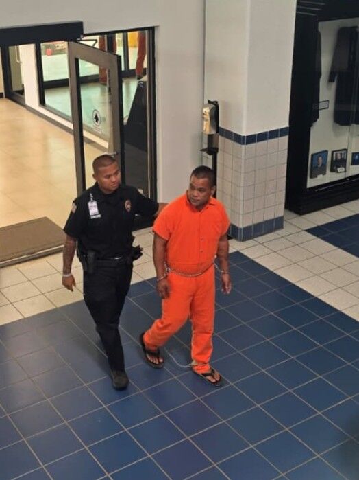 John Roman Lisua is escorted by a Corrections officer for a bail hearing Tuesday morning at the local courthouse.