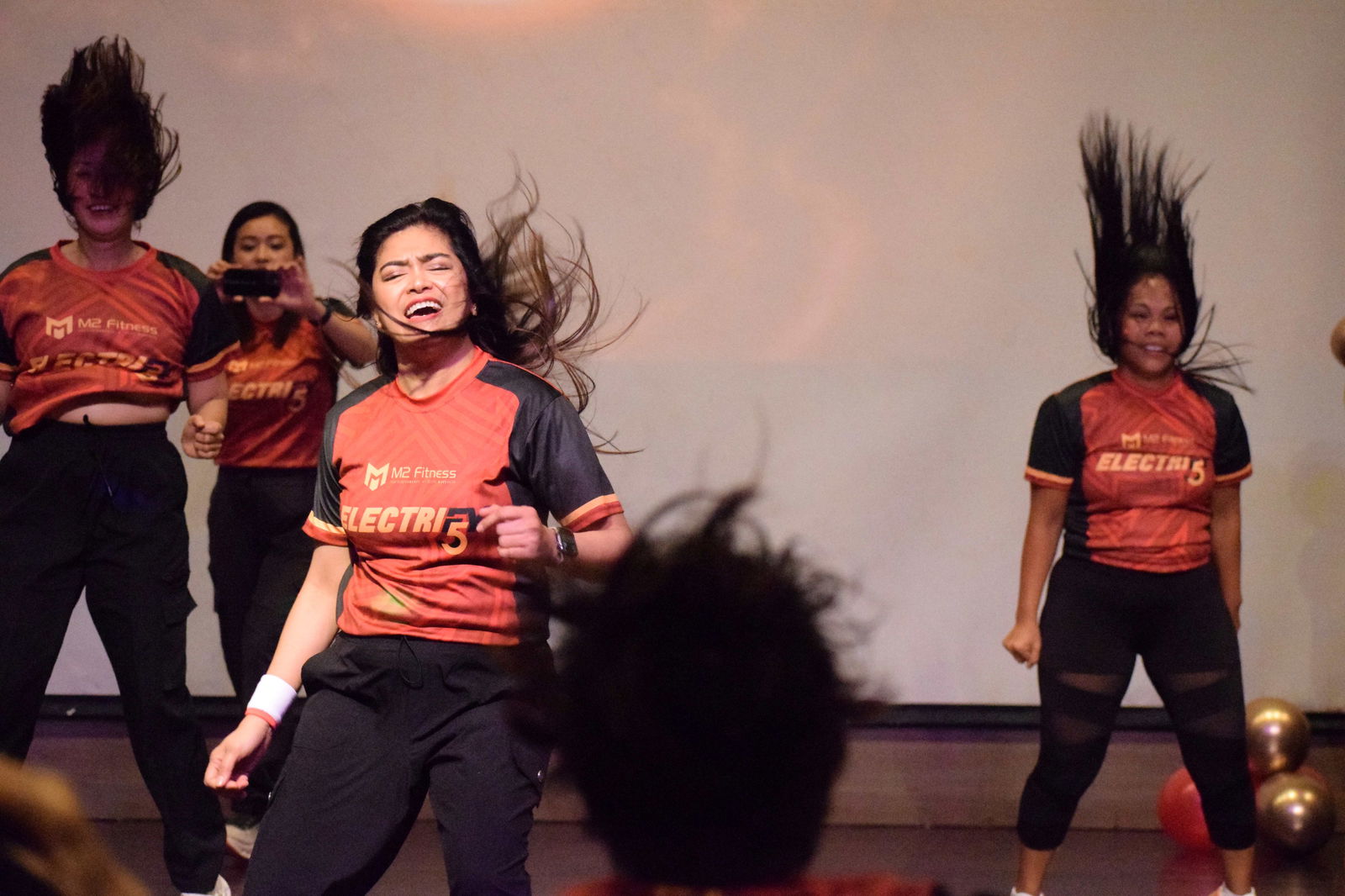 M2 Fitness founder Mary Grace Bautista leads a Zumba round as co-founder Mita Pelicano, second left, captures it on video.