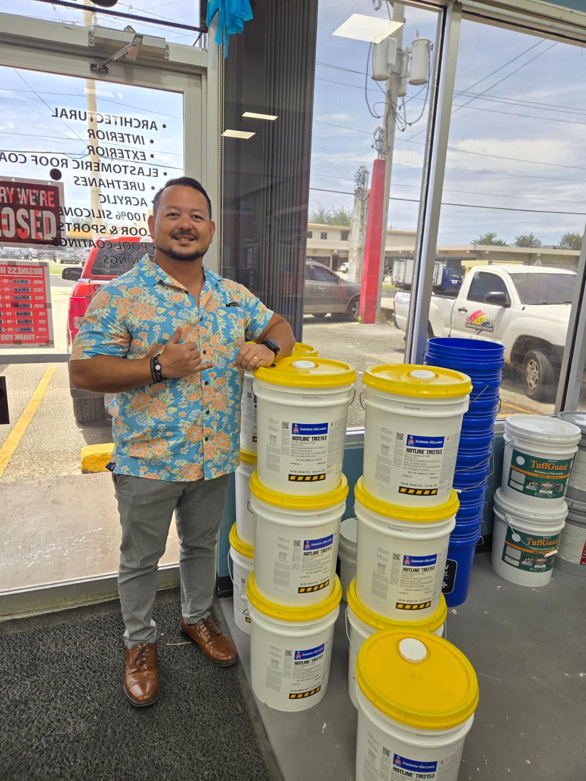 Rep. Joel Camacho poses with pails of paint for the highway beautification project in the north.Contributed photo