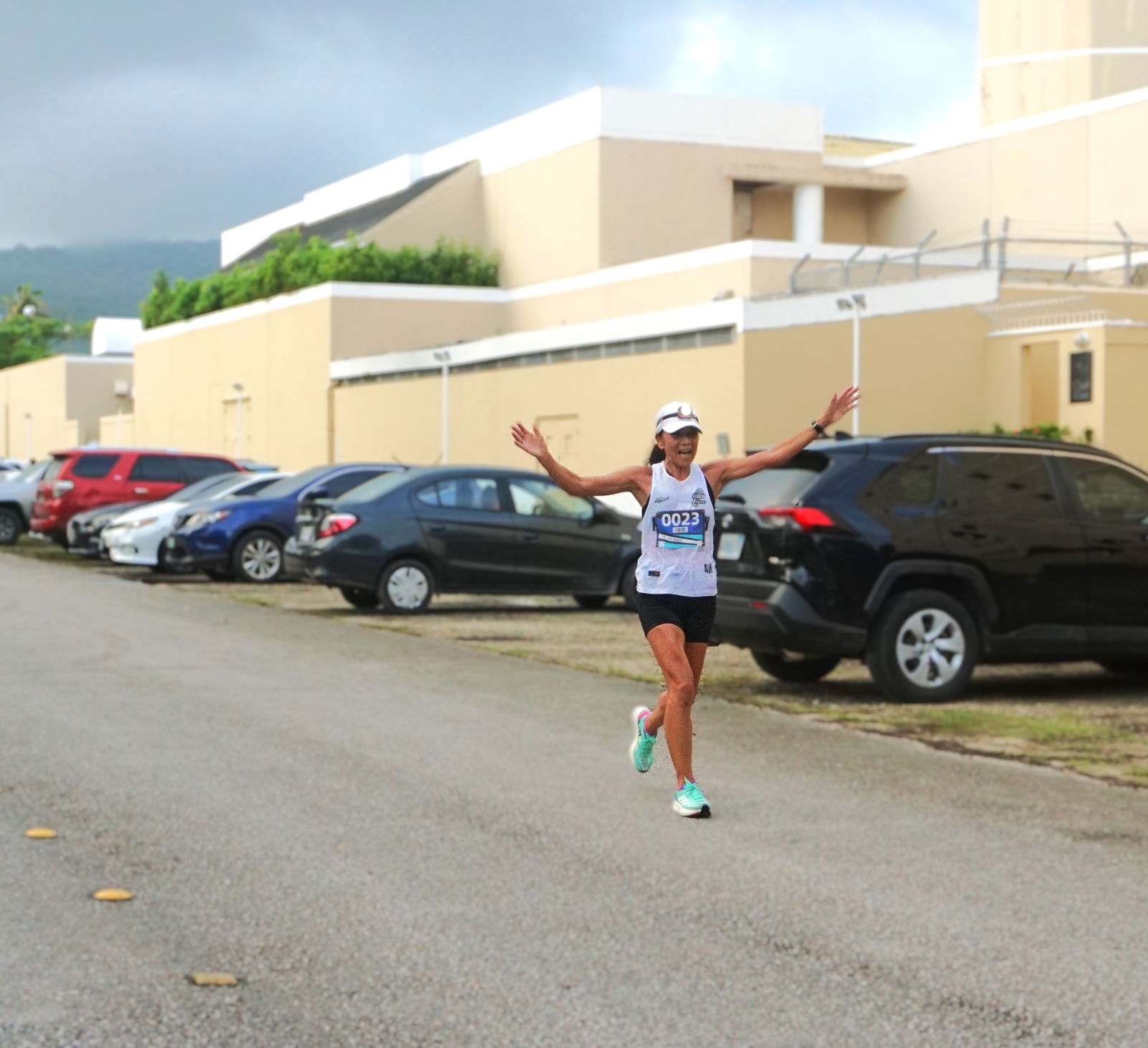 Akiko Miller celebrates as she nears the finish line of the Run Saipan Half Marathon 2025 on Micro Beach Road.