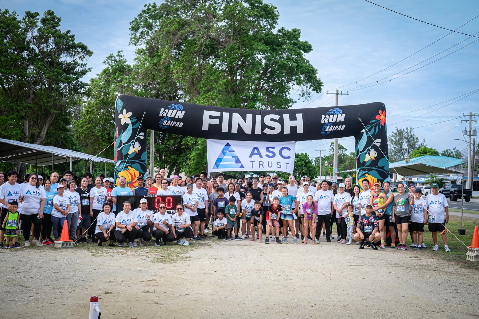 Participants and officials pose for a group photo before the start of Run Saipan’s inaugural ASC Trust 401K Day Sunset Strides 5K on Beach Road in Garapan, Friday.